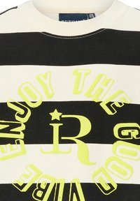 Bluza w paski z czarnymi i kremowymi poziomymi pasami, z odważnym nadrukiem żółtego tekstu i grafik, w tym gwiazdy i stylizowanego "R."