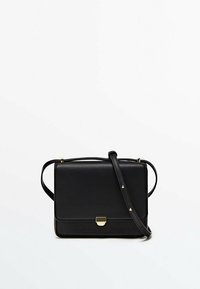 Schwarze Leder-Crossbody-Tasche mit rechteckiger Form, goldfarbener Hardware, magnetischem Verschluss und verstellbarem Riemen. Glatte Textur, minimalistisches Design.