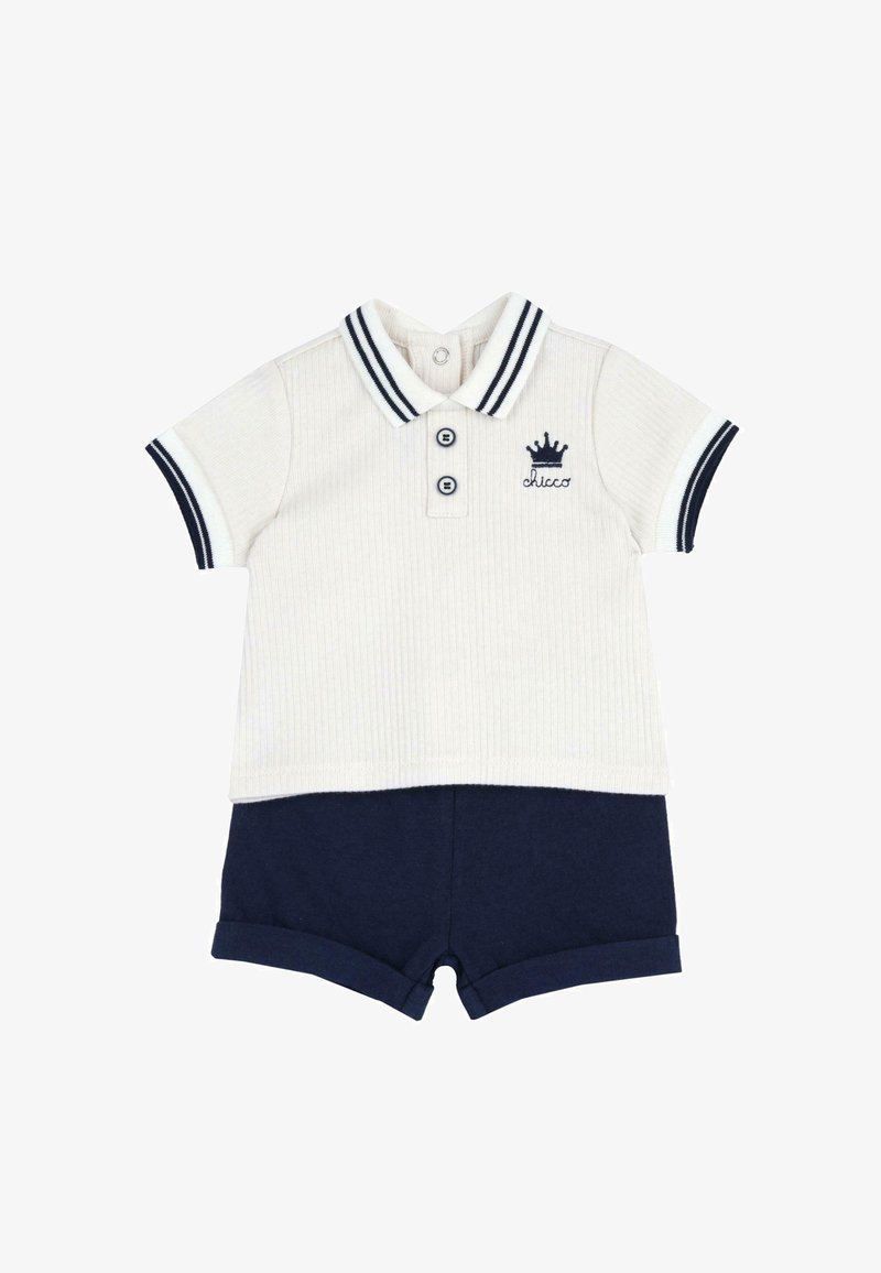 Polo shirt blanc à manches courtes avec une bordure marine et un logo de couronne, associé à un short marine à ourlet roulé pour les bébés garçons.