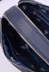 Námorně modrá kožená peněženka se dvěma zipovými přihrádkami a textilním podšíváním, které obsahuje logo U.S. Polo Assn. a motivy jezdců.