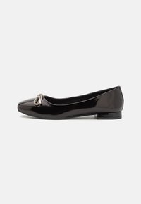 Ballerines en cuir noir verni avec un bout rond et un petit nœud en accent transparent à l'avant. Design à petit talon carré.