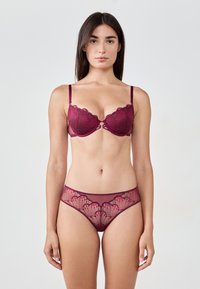 Reggiseno in pizzo bordeaux e mutandine coordinate con bordi scallopati e ricami floreali, con pannelli semi-trasparenti e spalline regolabili.