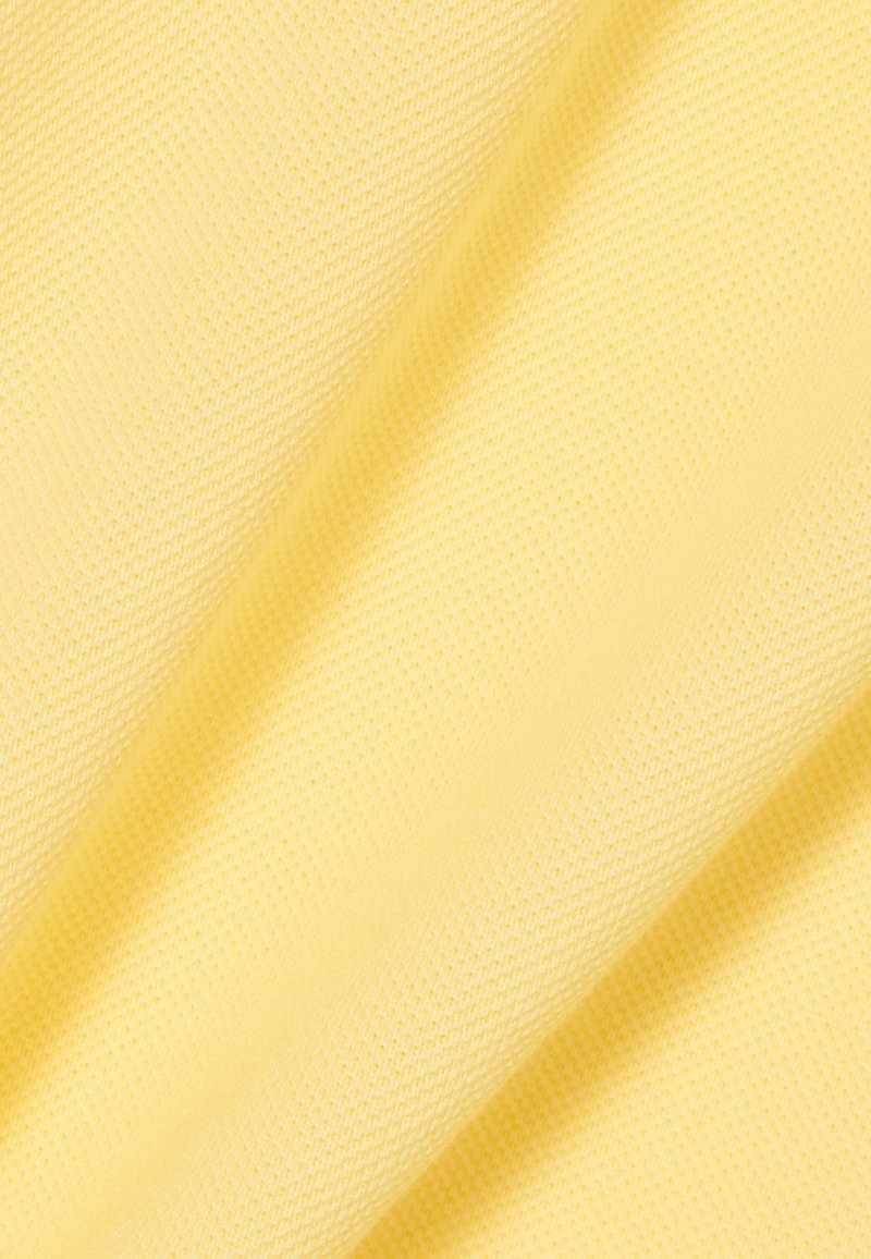 Tessuto tessile di colore giallo chiaro con superficie testurizzata a rete. Morbido e leggero, adatto per abbigliamento o accessori.