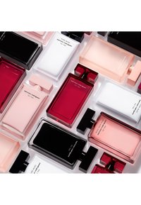 Colección de frascos de perfume en varias formas y tamaños. Los colores incluyen negro, blanco, rosa y rojo con acabados en vidrio transparente y mate.