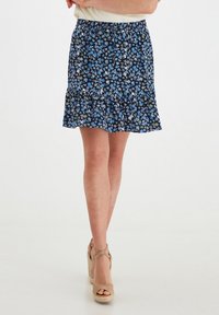 Falda corta acampanada en azul oscuro con un estampado floral en azul claro, blanco y verde. Presenta una cinturilla elástica y un dobladillo con volantes.