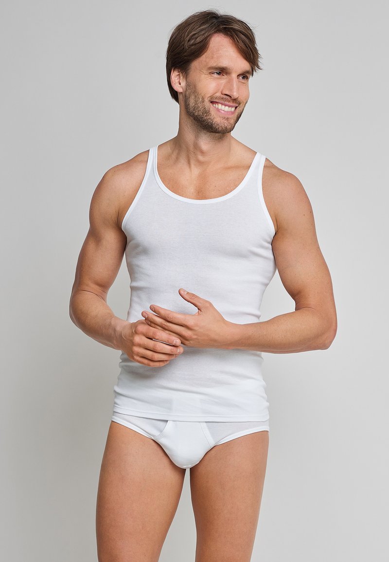 Hvid bomulds tanktop med en klassisk rund halsudskæring og slim fit, parret med hvide trusser. Glat tekstur og minimale designdetaljer.