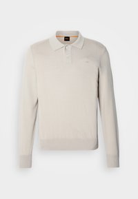 Ljusbeige långärmad polo tröja i mjukt stickat material, med en treknappsknäppning och ribbade ärmslut och nederkant. Diskret logotypdetalj.