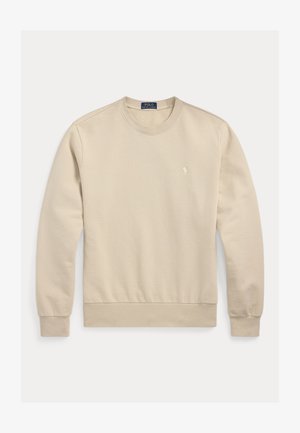 Beige bomullströja med rund halsringning, muddade ärmslut och nederkant. Har en liten broderad logga på bröstet. Slät textur, avslappnad design.