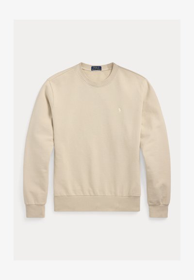 Sweatshirt bege em algodão com decote redondo, punhos e bainha canelados. Apresenta pequeno logotipo bordado no peito. Textura suave, design casual.