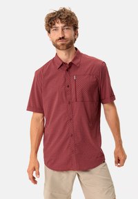 Camisa de cuadros burdeos de manga corta con botones en la parte delantera, bolsillo en el pecho y cuello. Cuenta con una tela ligera y un corte holgado.