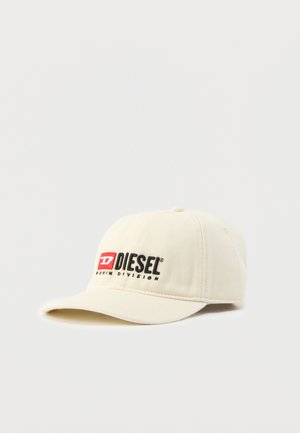 Bež baseball kapa z vezenim črnim napisom "DIESEL" in rdečim poudarkom. Ima strukturiran dizajn in ukrivljen rob. Izdelana je iz bombažnega materiala.