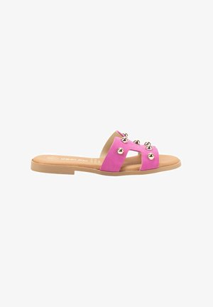 Sandal de ante rosa con dos correas anchas adornadas con tachuelas metálicas redondas. Suela plana con plantilla beige y diseño minimalista.