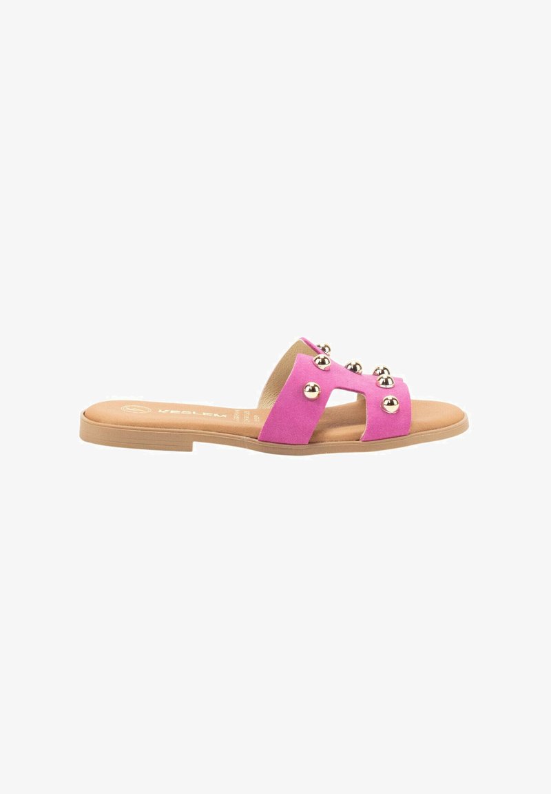 Sandal de ante rosa con dos correas anchas adornadas con tachuelas metálicas redondas. Suela plana con plantilla beige y diseño minimalista.