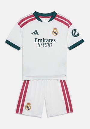 Equipación blanca del Real Madrid con franjas granate, cuello verde y ribete en las mangas, con los logotipos de Adidas y Emirates.