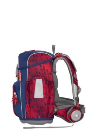 Sac à dos rouge et bleu avec un motif géométrique, des bretelles rembourrées grises, des poches latérales et un support pour écouteurs au design circulaire.