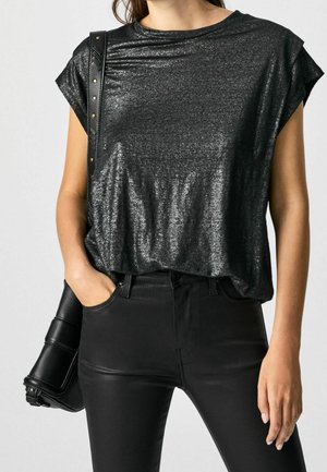 Black metallic T-shirt with rolled sleeves, featuring a relaxed fit and smooth texture; paired with black fitted jeans and a structured handbag.