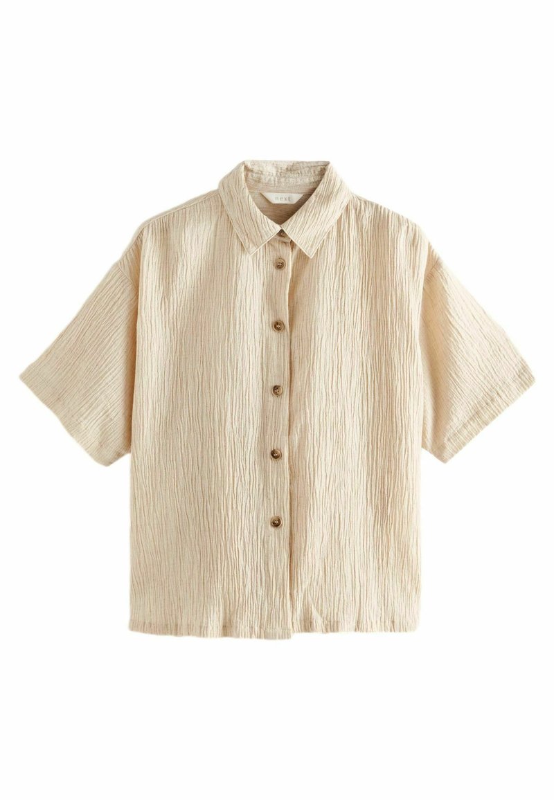Kortærmet, beige skjorte lavet af struktureret stof, der har en knaplukning foran og en klassisk krave, med fire brune knapper.