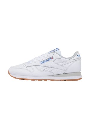 Witte Reebok lage sneaker met blauw logo, witte veters, grijze binnenvoering en gum rubberen zool, gezien vanaf de zijkant.