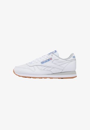 Baskets basses blanches Reebok avec logo bleu, lacets blancs, doublure intérieure grise et semelle en gomme, vues de côté.