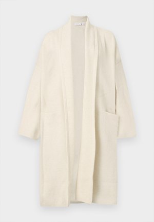 Langer cremefarbener Cardigan mit offenem Vorderteil, zwei Fronttaschen und breiten Revers, auf weißem Hintergrund präsentiert.