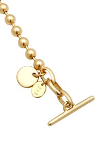 Guldpläterat metallarmband med sfäriska pärlor, en toggle-lås, och två runda taggar med stämplade gravyrer.