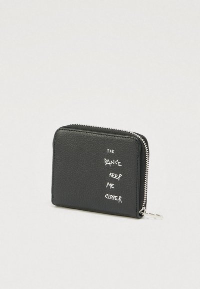 Zwart gestructureerd portemonnee met zilveren rits en witte tekst "The dance keep me closer" aan de voorkant.