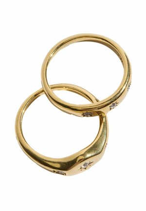 Zwei goldene Ringe mit kleinen eingefassten Steinen auf weißem Hintergrund angeordnet, ein Ring überlappt leicht den anderen.