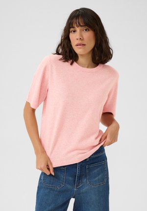 Pull court à manches courtes rose clair avec un col rond côtelé, fabriqué dans un tissu doux et texturé. Assorti à un jean en denim bleu.