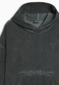 Szary hoodie wykonany z miękkiego materiału, z dużym kapturem, przednią kieszenią, subtelnie zdobionym logo i teksturowanym wykończeniem.
