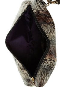 Přehnaná taška z hadí kůže v odstínech hnědé a krémové, s tmavě fialovým interiérem a horním zipovým uzávěrem.