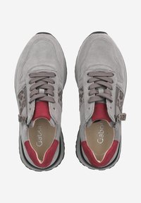 Grijze suède sneakers met een rode en luipaardprint accent, met een vetersluiting ontwerp en een zwarte rubberen zool.