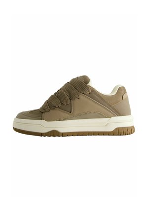 Baskets basses marron avec des lacets épais et texturés, un col rembourré et une semelle blanche avec une bande de roulement marron sur fond blanc.
