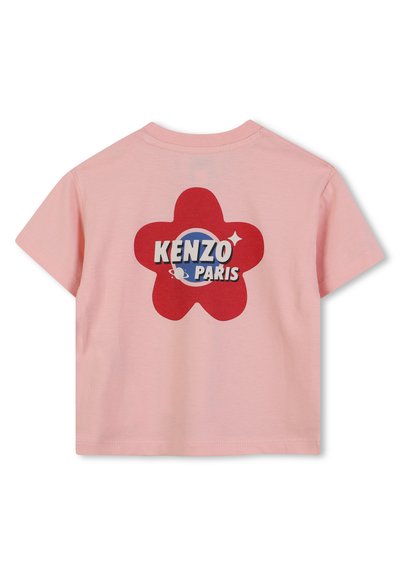 Różowa bawełniana koszulka z krótkim rękawem z czerwonym graficznym motywem w kształcie kwiatu na plecach, z napisem "KENZO PARIS" w niebieskim i białym kolorze. Okrągły dekolt.