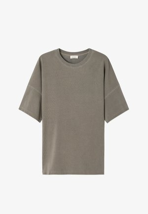 Korte mouwen, oversized t-shirt in gedempte olijfgroene kleur, gemaakt van geribbelde stof met een ronde hals en rauwe zoomdetails.