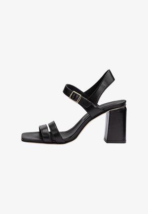 Sandale à talon haut en cuir noir avec bout carré, deux brides frontales, bride de cheville avec boucle dorée et talon épais bloc.