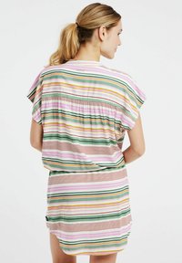 Vestido a rayas con líneas de diferentes anchos en rosa, verde, amarillo y rojo. Tela suave, mangas cortas y un corte holgado con la parte posterior fruncida.