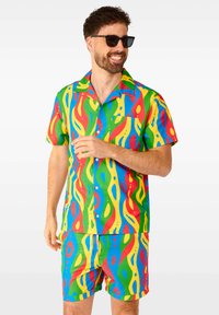 Bunt bedrucktes Kurzarmhemd und passende Shorts aus leichtem Stoff, die ein mehrfarbiges Wellenmuster in Rot, Grün, Gelb und Blau aufweisen.