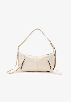 Beige Lederschultertasche mit verstellbarem Riemen, zwei vorderen Reißverschlusstaschen und verlängerten Reißverschlussanhängern vor weißem Hintergrund.