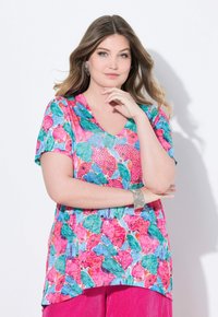 Top maniche corte a V in tonalità vivaci di rosa, verde e blu, caratterizzato da un motivo floreale e realizzato in tessuto leggero.
