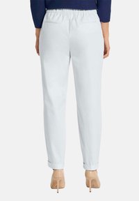 Witte, lichte broek met elastische tailleband en een rechtbenig ontwerp, voorzien van opgerolde enkelranden en twee achterzakken.