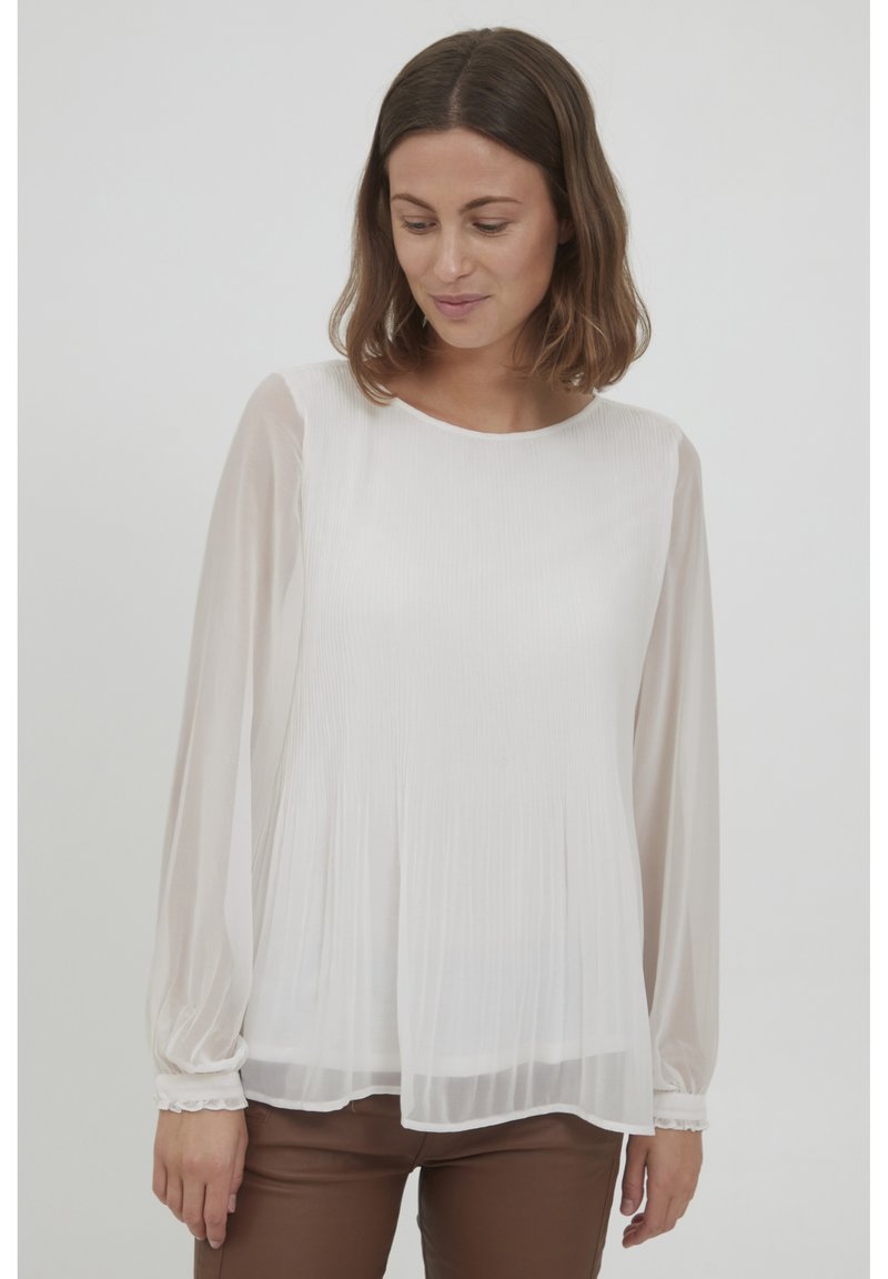 Weiße plissierte Bluse mit langen Ärmeln, runder Halslinie und Rüschenbündchen. Hergestellt aus leichtem, durchscheinendem Stoff. Bietet sanfte Drapierung.