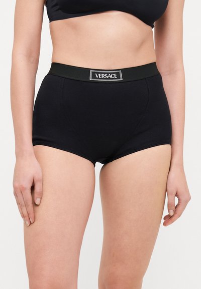 Braguitas de algodón negras de talle alto con textura acanalada y una amplia cinturilla elástica que presenta una etiqueta del logo de Versace en blanco.