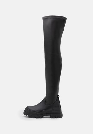 Black over-the-knee rain boots made of smooth rubber with a chunky sole, round toe, and elastic side panels for easy wear.