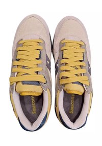 Sneaker beige con lacci gialli, materiali in rete e suede, accenti grigi, punta rotonda e colletto imbottito. Logo visibile sulle solette.