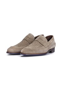 Mocassins en daim beige clair avec un motif tissé sur le bout, dotés d'une semelle plate et d'un léger talon. Texture lisse sur l'ensemble.