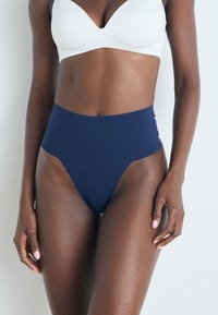 Hoog uitgesneden marineblauwe onderbroek met een soepele textuur en een minimalistisch ontwerp, voorzien van een brede elastische tailleband en een string snit.