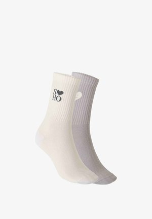 Chaussettes en coton crème et lilas, texture côtelée. La chaussette crème porte un logo noir "SOHO" ; la lilas est ornée d'un accent en forme de cœur. Longueur cheville.