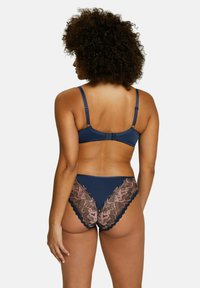 Conjunto de ropa interior azul marino que incluye un sujetador acanalado y unas bragas con encaje en los bordes y detalles intrincados de un patrón de rosas. Tirantes ajustables y cierre en la parte posterior.