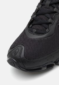 Pantofii sport negri au un superior din plasă, talpă din cauciuc și vârf întărit. Include un design cu șireturi și suport căptușit pentru gleznă.