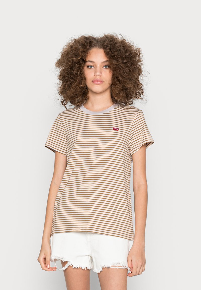 T-shirt de mangas curtas às riscas em bege e castanho com um decote redondo branco. Apresenta um pequeno logótipo vermelho no lado esquerdo do peito. Usado com calções brancos.